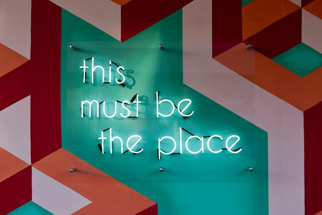 Painted wall design with "this must be the place" neon lights